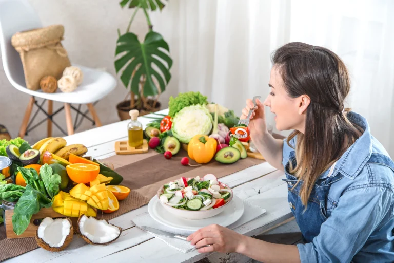 young-happy-woman-eating-salad-table.webp