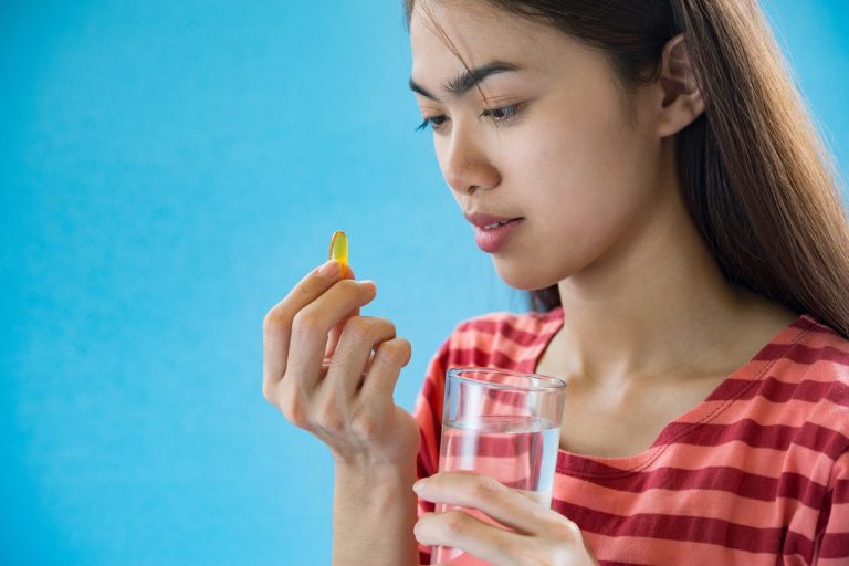 young woman taking medicine pill after doctor order